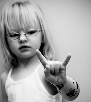Little girl with horns up.